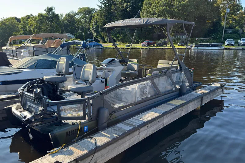 The Image of 2025 Sea-Doo Switch Fish 21 docked on a sunny day, surrounded by boats. - 0