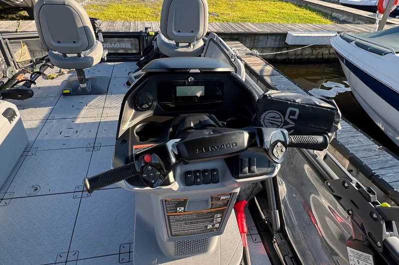 Slide: The Image of 2025 Sea-Doo Switch Fish 21 dashboard and seating area at a dock. - 12