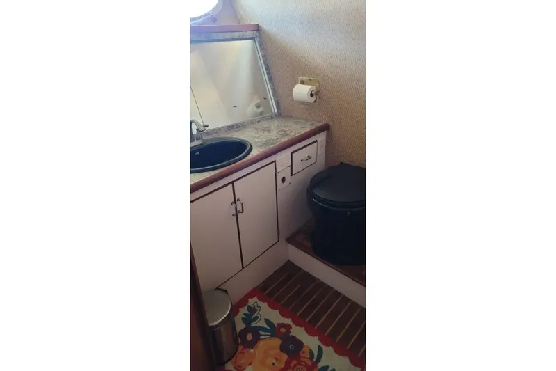 Slide: The Image of 1978 Symbol Double Deck Cockpit MY bathroom with sink, mirror, and black toilet. - 6