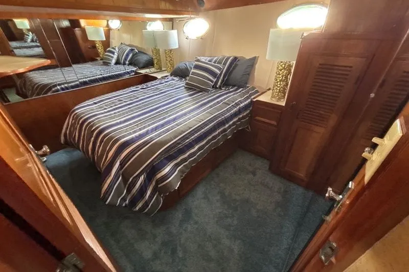 Slide: The Image of Cozy bedroom in 1987 Symbol MS Super Sedan yacht with striped bedding and wooden furnishings. - 13