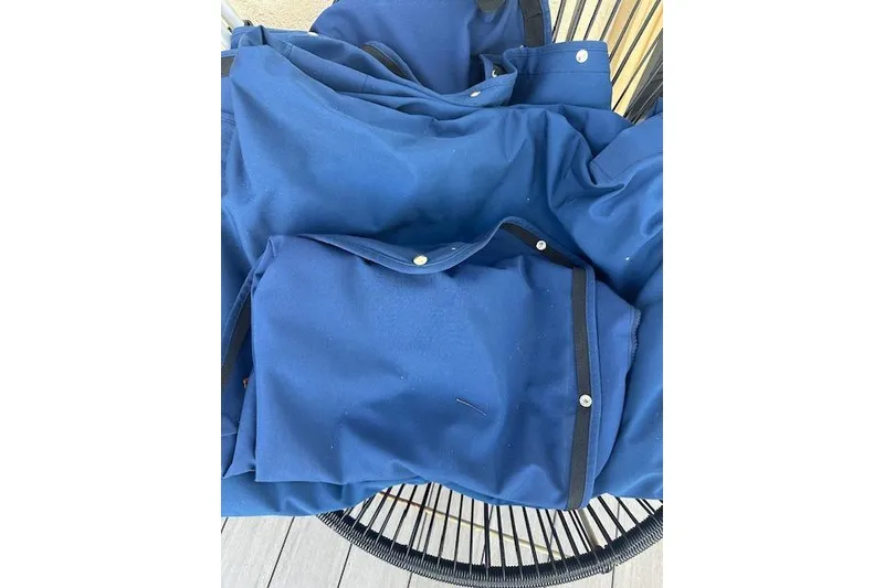 Slide: The Image of Blue boat cover for 2022 Sea Ray SPX 210, folded on a chair. - 17