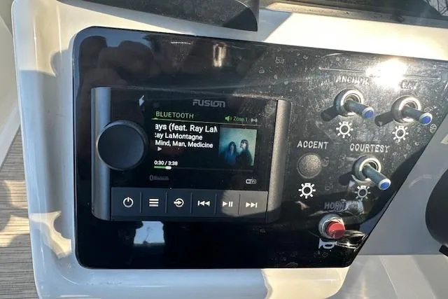 Slide: The Image of Control panel of 2022 Sea Ray SPX 210 boat with music player and switches. - 25