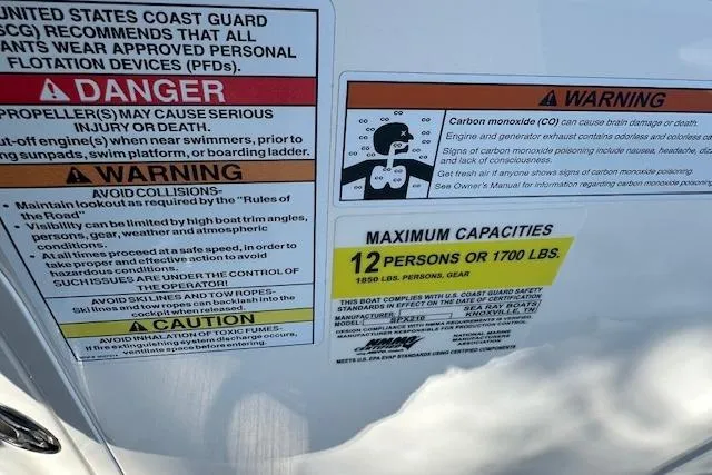 Slide: The Image of Warning labels on a 2022 Sea Ray SPX 210 boat, indicating safety and capacity limits. - 18