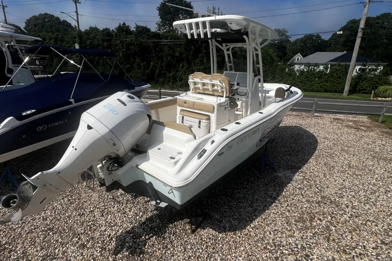 Slide: The Image of 2019 Key West 239 FS boat with outboard motor on gravel lot. - 2