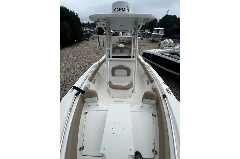 Slide: The Image of 2019 Key West 239 FS boat interior with seating and Garmin equipment, docked outdoors. - 12