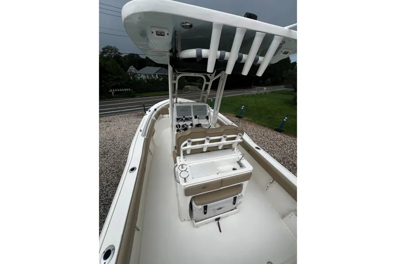 Slide: The Image of 2019 Key West 239 FS boat interior with console and seating, parked on gravel. - 5