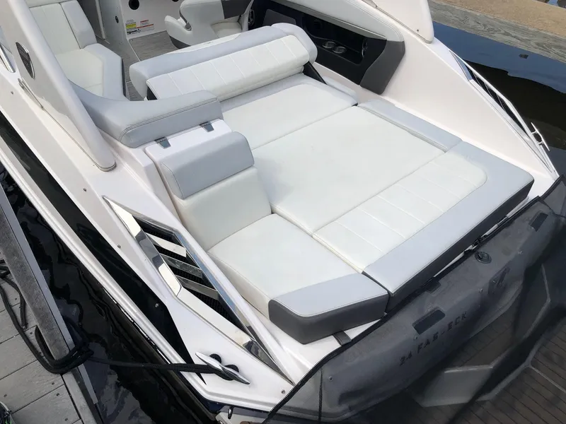 Slide: The Image of The image shows the sun deck of a 2014 Regal 24 FasDeck boat with white upholstery. - 14