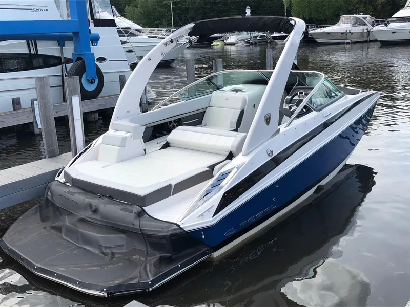 The Image of 2014 Regal 24 FasDeck in a marina, featuring a blue hull and white interior. - 2