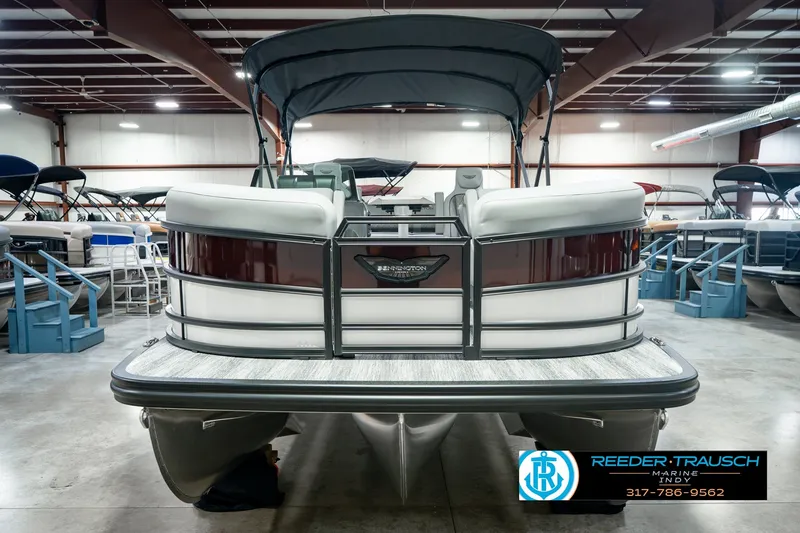 Slide: The Image of 2027 Bennington 22 MSB pontoon boat in showroom, featuring sleek design and spacious seating. - 4