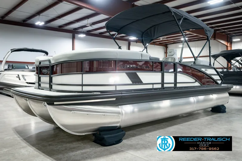 Slide: The Image of 2027 Bennington 22 MSB pontoon boat in showroom with canopy and sleek design. - 2