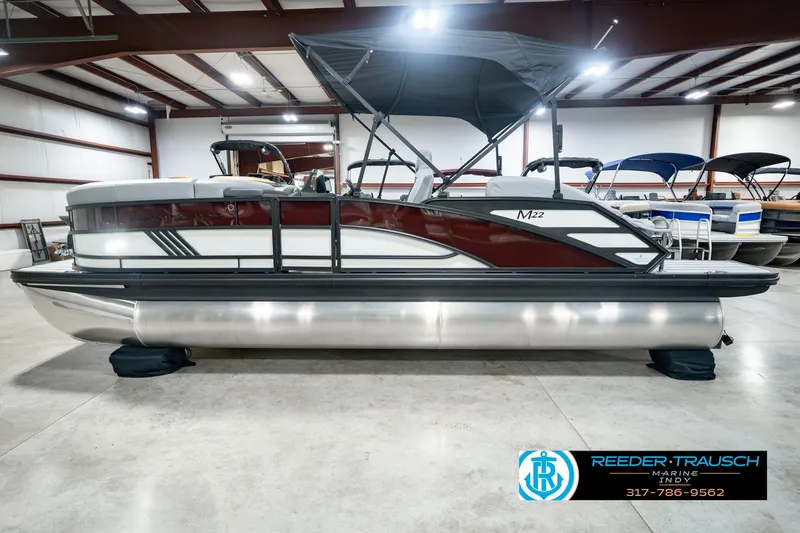 Slide: The Image of 2027 Bennington 22 MSB pontoon boat in showroom with canopy and sleek design. - 12