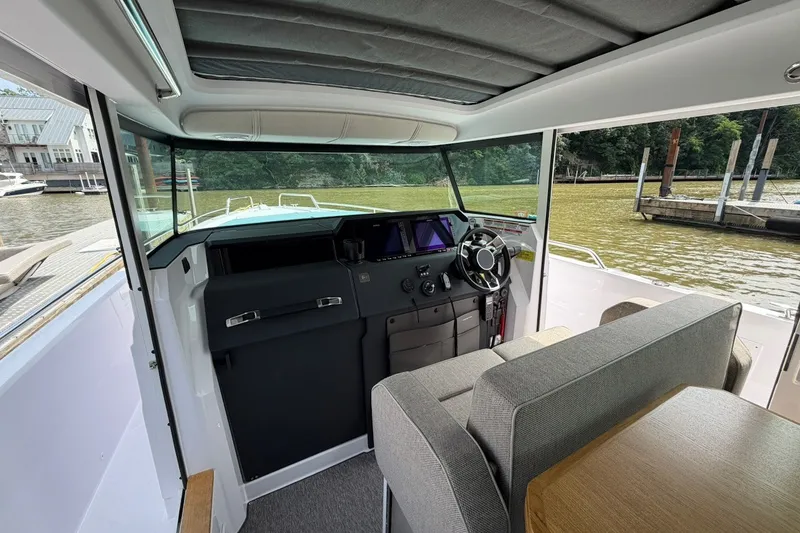 Slide: The Image of Interior view of 2025 Axopar 37 XC Cross Cabin, featuring helm and seating area. - 13