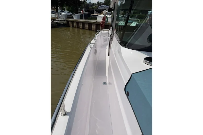 Slide: The Image of 2025 Axopar 37 XC Cross Cabin boat docked, showcasing sleek side deck design. - 28