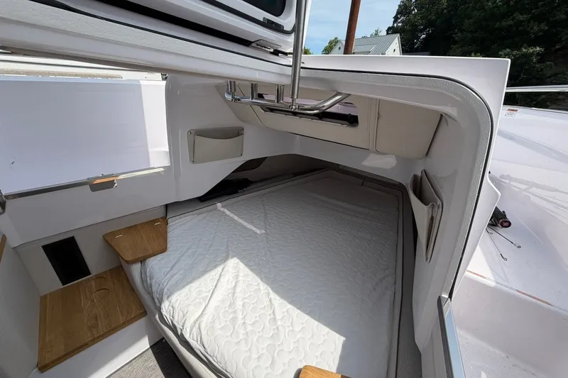 Slide: The Image of 2025 Axopar 37 XC Cross Cabin interior with cozy bed and wooden accents. - 21