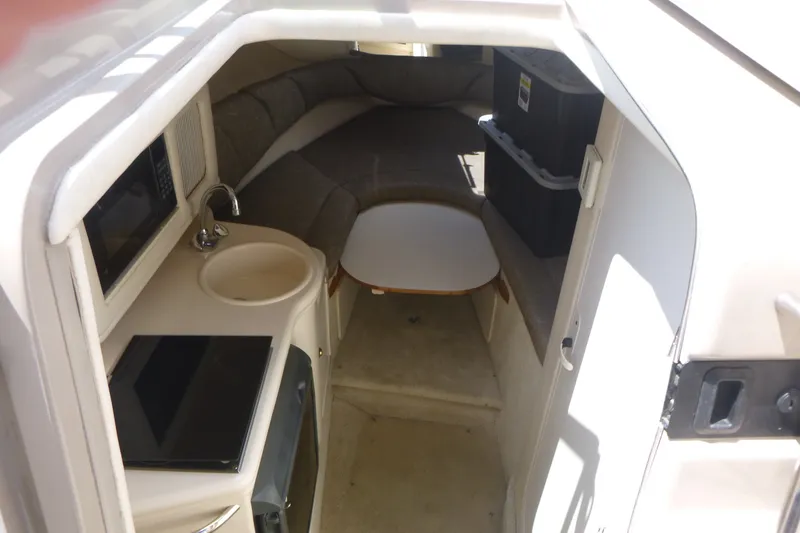 Slide: The Image of Interior of 2002 Sea Ray Sundancer 260 boat with kitchenette and seating area. - 8