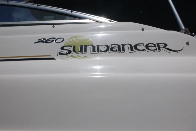 Slide: The Image of 2002 Sea Ray Sundancer 260 boat logo on white hull, featuring sleek design elements. - 21