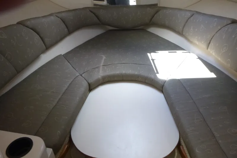 Slide: The Image of Interior cabin of 2002 Sea Ray Sundancer 260 with cushioned seating and table. - 11
