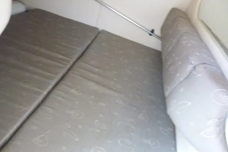 Slide: The Image of Interior cabin bed of 2002 Sea Ray Sundancer 260 boat, featuring patterned upholstery. - 9