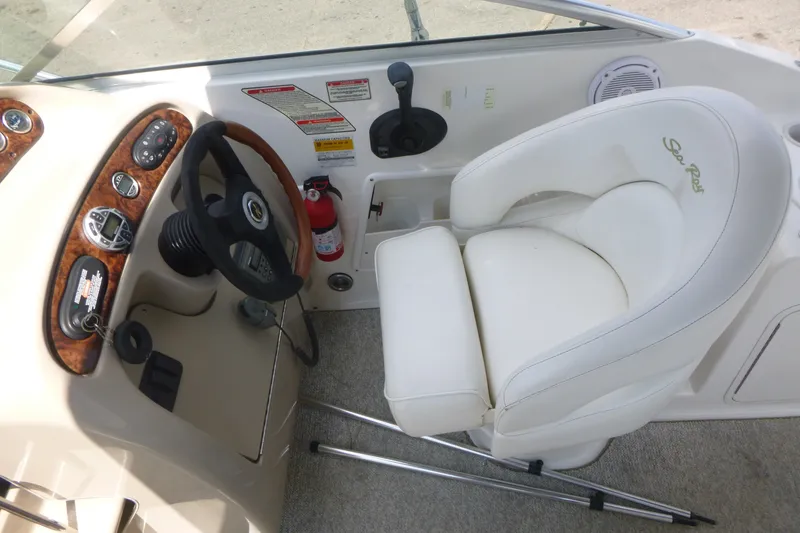 Slide: The Image of 2002 Sea Ray Sundancer 260 helm with steering wheel, controls, and white captain's chair. - 12