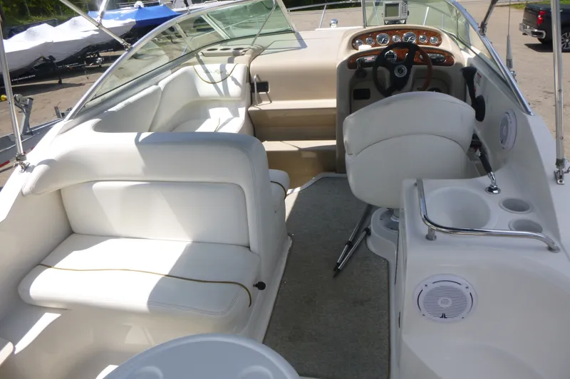 Slide: The Image of Interior of a 2002 Sea Ray Sundancer 260 boat, featuring white seating and helm. - 6