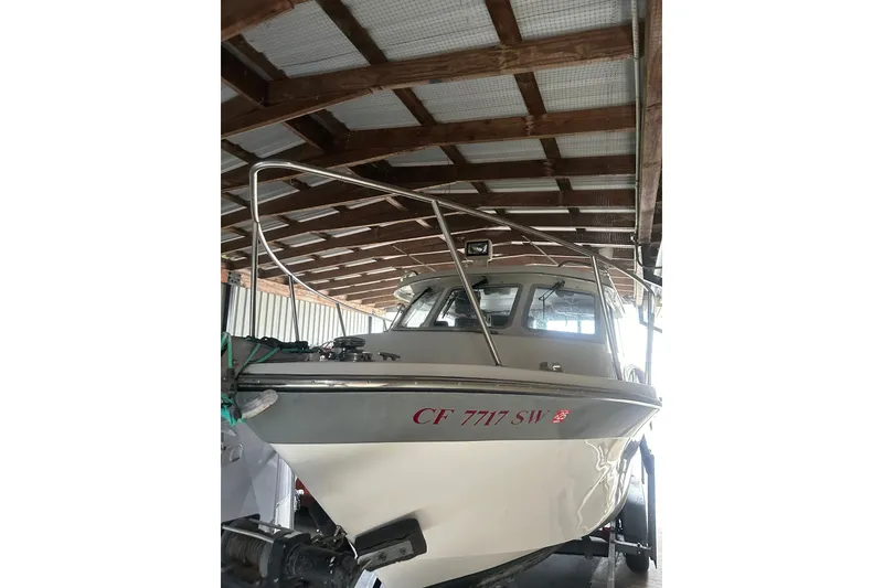 Slide: The Image of 1999 Orca 24 boat in covered storage, front view with visible registration number. - 1
