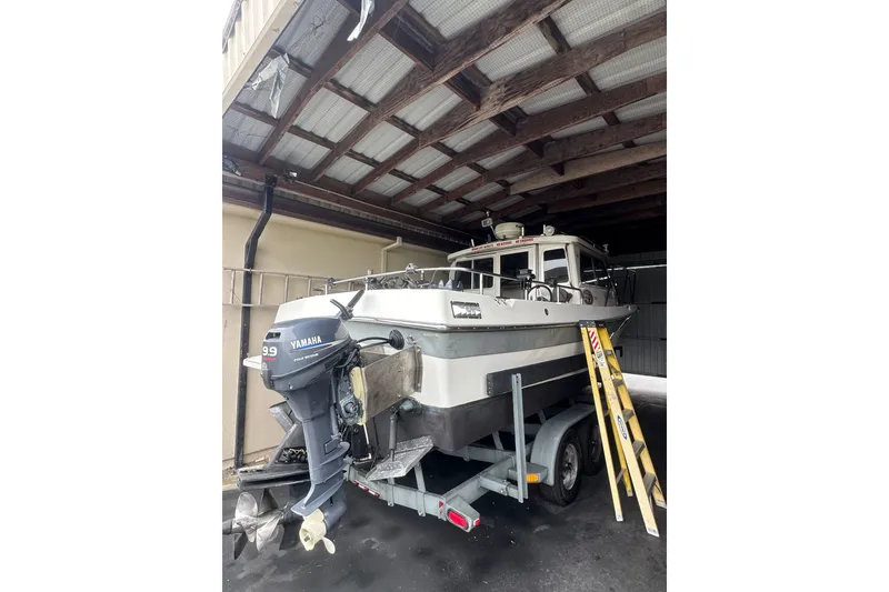 Slide: The Image of 1999 Orca 24 boat with Yamaha motor on trailer under a shelter. - 5