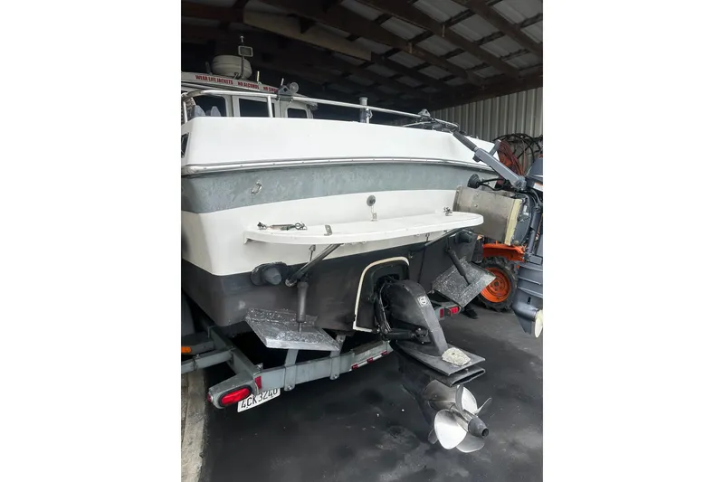 Slide: The Image of 1999 Orca 24 boat in storage, showing rear view with propeller and trailer. - 4