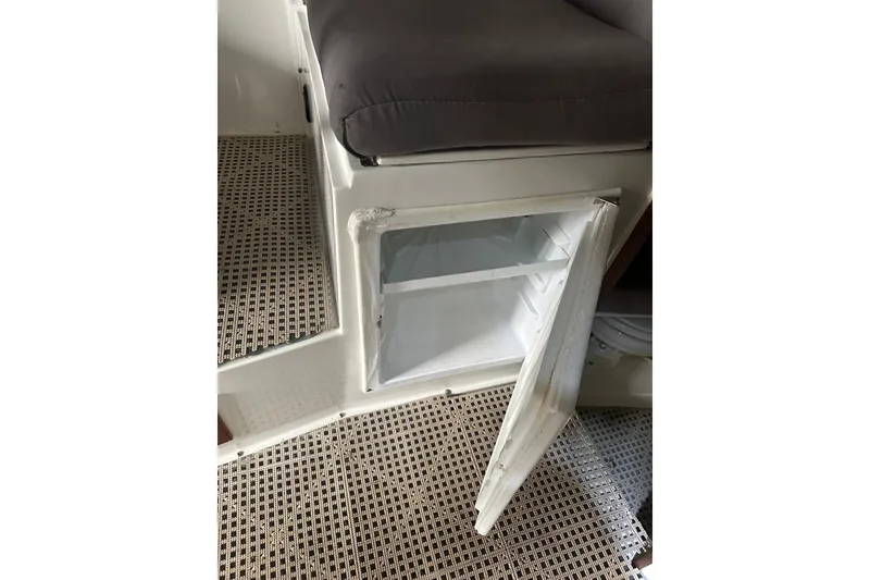 Slide: The Image of Interior of 1999 Orca 24 boat showing open storage compartment and cushioned seating. - 31