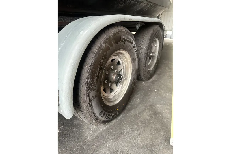 Slide: The Image of Trailer wheels of a 1999 Orca 24 boat, featuring Strong Guard tires. - 40