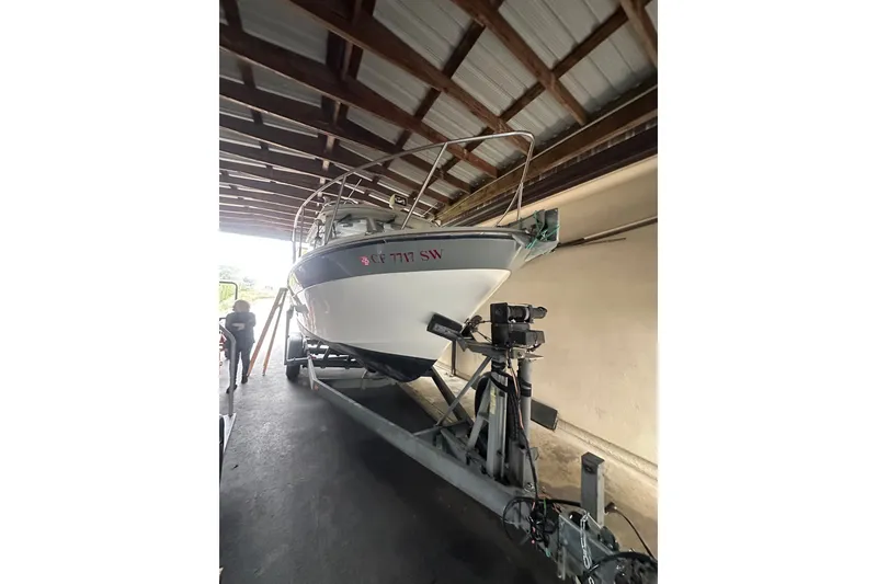 Slide: The Image of 1999 Orca 24 boat on trailer under shelter, front view. - 2