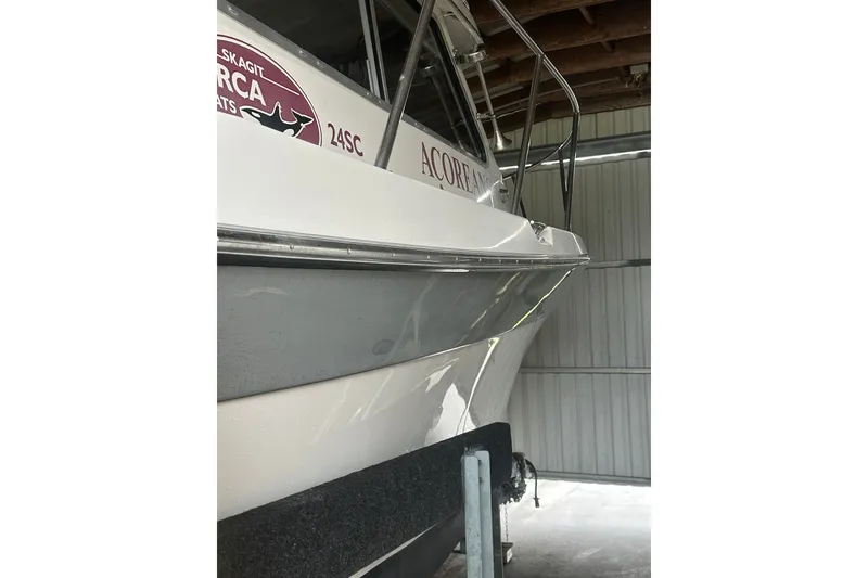 Slide: The Image of 1999 Orca 24 boat in storage, showcasing sleek design and branding details. - 3