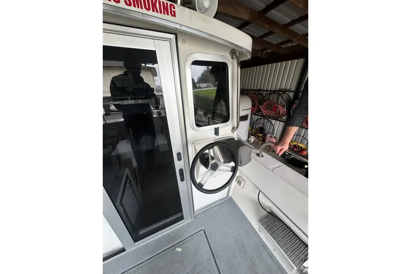 Slide: The Image of Interior view of a 1999 Orca 24 boat, featuring steering wheel and cabin details. - 8