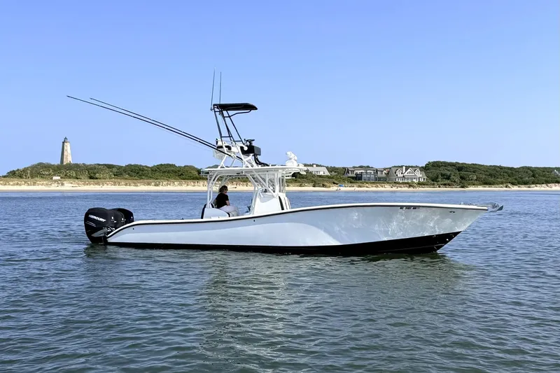 The Image of 2008 Yellowfin 36 Offshore boat on calm water near a lighthouse and shoreline. - 1
