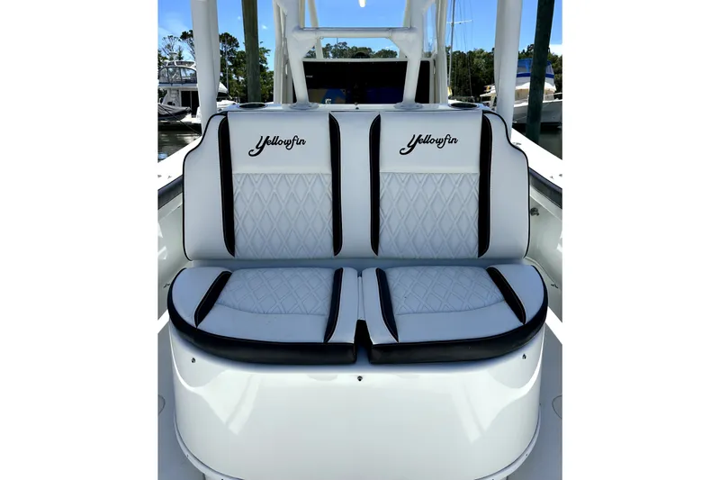 Slide: The Image of 2008 Yellowfin 36 Offshore boat seating with logo, featuring white and black upholstery. - 16
