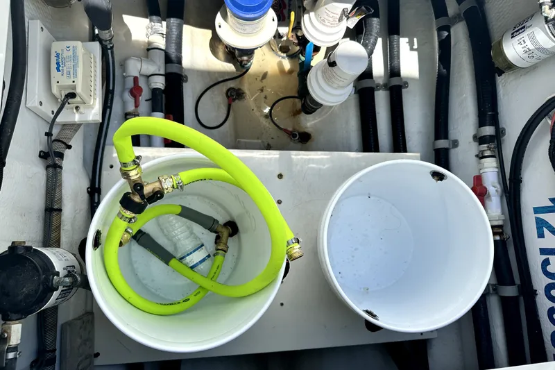 Slide: The Image of Engine compartment of a 2008 Yellowfin 36 Offshore boat with hoses and equipment. - 24
