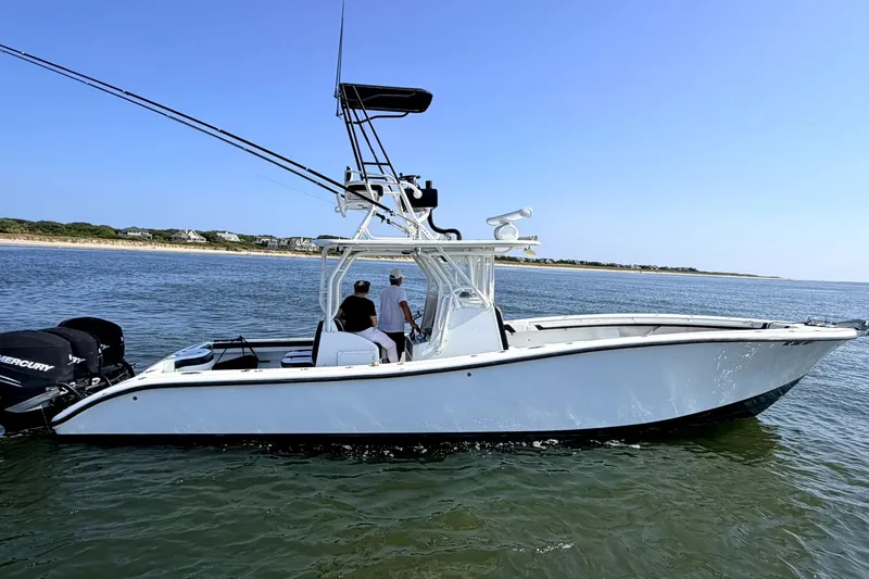 Slide: The Image of 2008 Yellowfin 36 Offshore boat on calm water with two people onboard. - 9