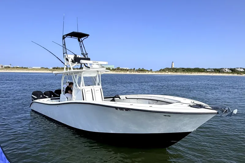 Slide: The Image of 2008 Yellowfin 36 Offshore boat on calm water near a scenic shoreline. - 8