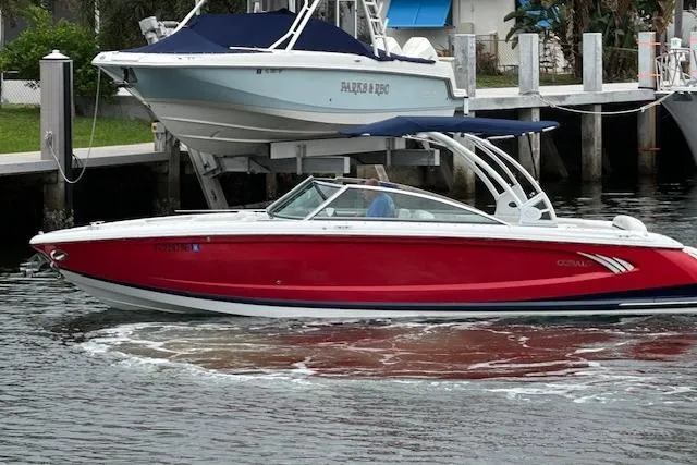 Slide: The Image of 2016 Cobalt A28 boat in vibrant red, cruising on a calm waterway. - 22