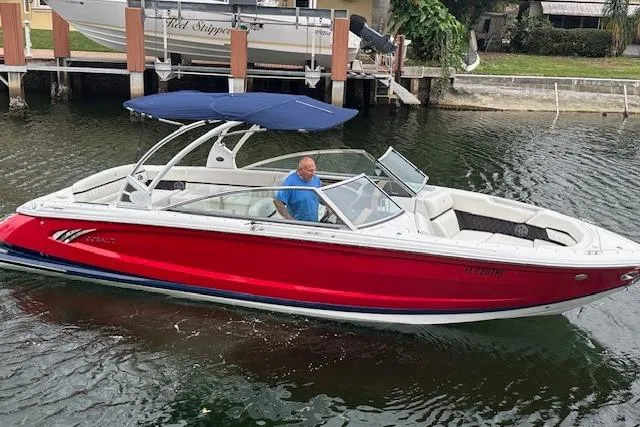 Slide: The Image of 2016 Cobalt A28 boat with red hull and blue canopy cruising on a canal. - 27