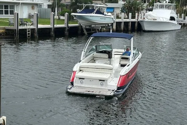Slide: The Image of 2016 Cobalt A28 boat cruising in a canal near docked vessels. - 25