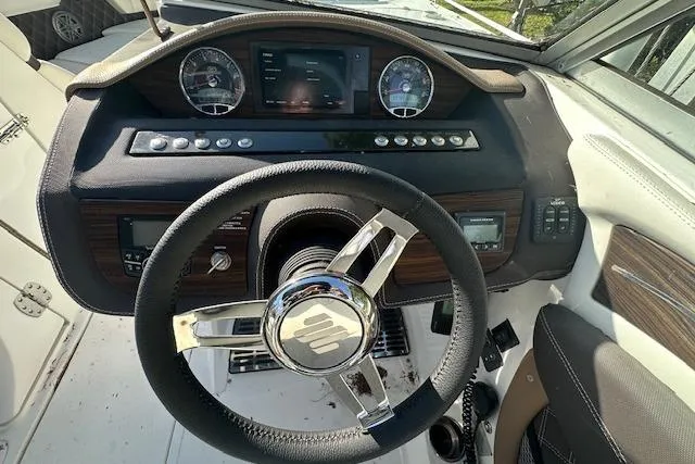 Slide: The Image of Steering wheel and dashboard of a 2016 Cobalt A28 boat, featuring modern controls and gauges. - 48