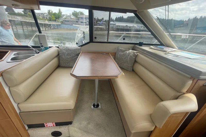 Slide: The Image of Interior of 1999 Bayliner 4087 Aft Cabin Motoryacht with beige seating and wooden table. - 17