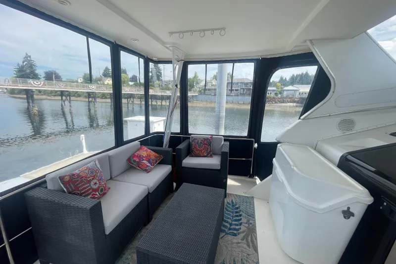 Slide: The Image of 1999 Bayliner 4087 Aft Cabin Motoryacht interior with cozy seating and waterfront view. - 4