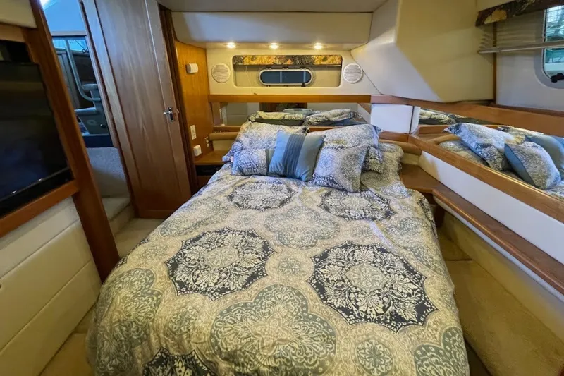 Slide: The Image of Cozy bedroom in 1999 Bayliner 4087 Aft Cabin Motoryacht with patterned bedding and wood accents. - 30
