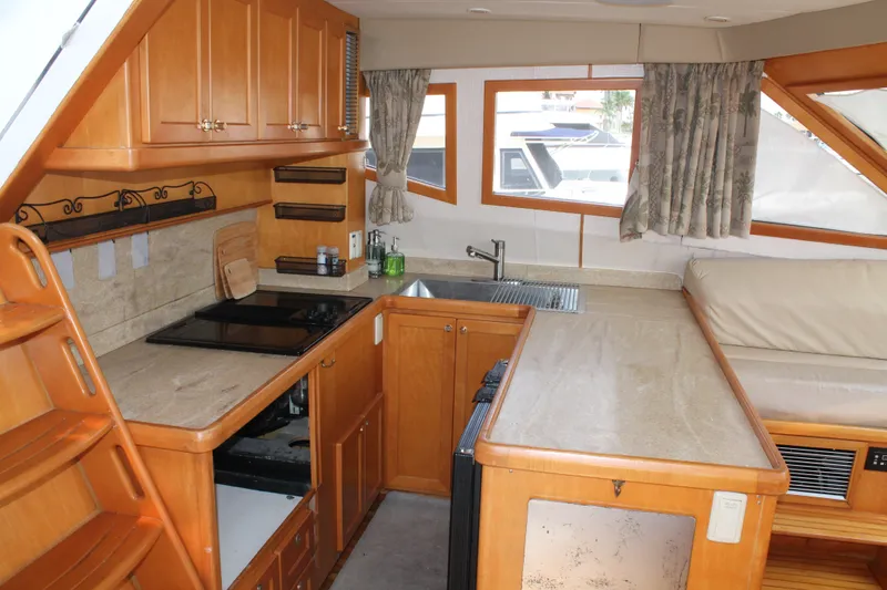 Slide: The Image of Interior of 1997 McKinna 48 Pilothouse yacht featuring a cozy kitchen and seating area. - 15