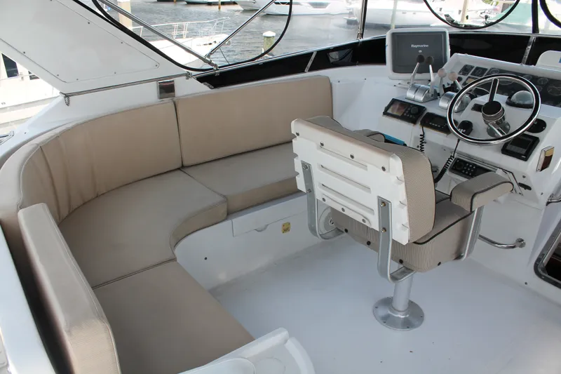 Slide: The Image of 1997 McKinna 48 Pilothouse helm with seating, steering wheel, and navigation equipment. - 51