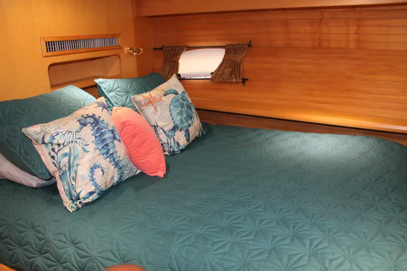 Slide: The Image of Cozy bedroom in 1997 McKinna 48 Pilothouse with nautical-themed pillows and teal bedding. - 31