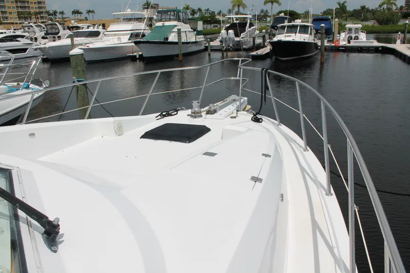 Slide: The Image of 1997 McKinna 48 Pilothouse yacht docked at marina with other boats. - 57