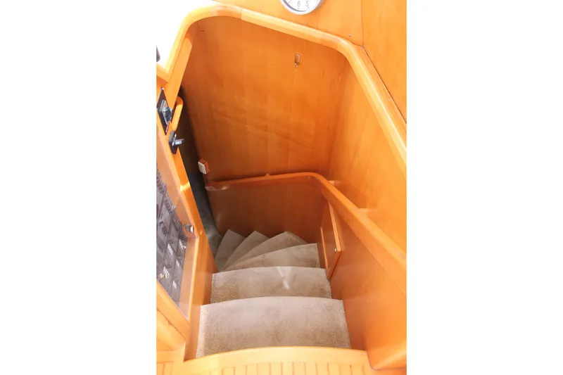 Slide: The Image of Staircase inside 1997 McKinna 48 Pilothouse yacht with wooden paneling and carpeted steps. - 24