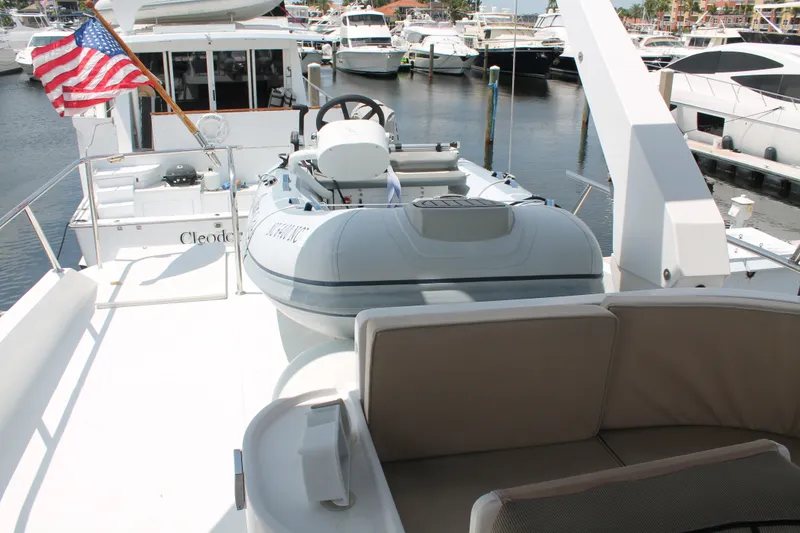 Slide: The Image of 1997 McKinna 48 Pilothouse yacht with dinghy and American flag at marina. - 48